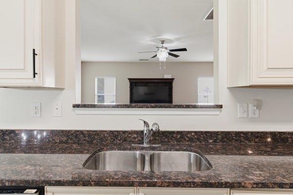 4925 Locherby Drive Fairburn, GA 30213 - Photo 22 of 85 a kitchen with granite countertop a sink and a stove top oven