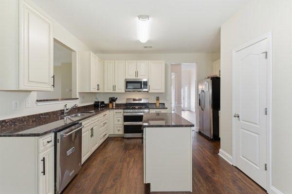 4925 Locherby Drive Fairburn, GA 30213 - Photo 23 of 85 a kitchen with stainless steel appliances granite countertop a stove top oven a refrigerator a sink and dishwasher with white cabinets