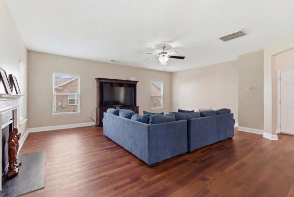 4925 Locherby Drive Fairburn, GA 30213 - Photo 27 of 85 a living room with couches and a flat screen tv with wooden floor