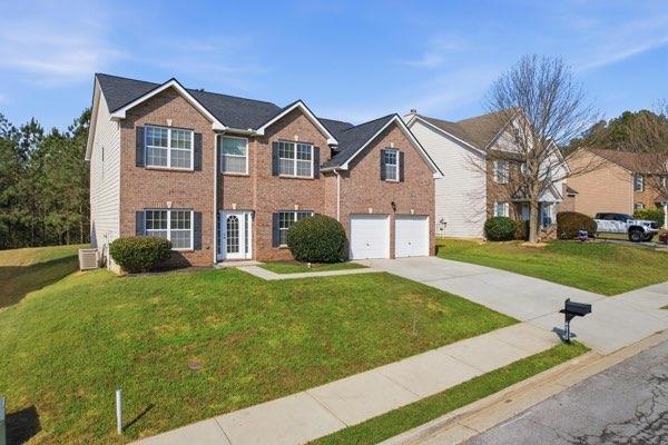 4925 Locherby Drive Fairburn, GA 30213 - Photo 5 of 85 a front view of a house with a yard and garage