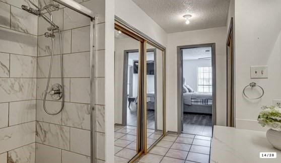 562 Stringfellow Drive Coppell, TX 75019 - Photo 9 of 24 Shower stall with a glass enclosure, white rectangular wall tiles, and chrome fixtures