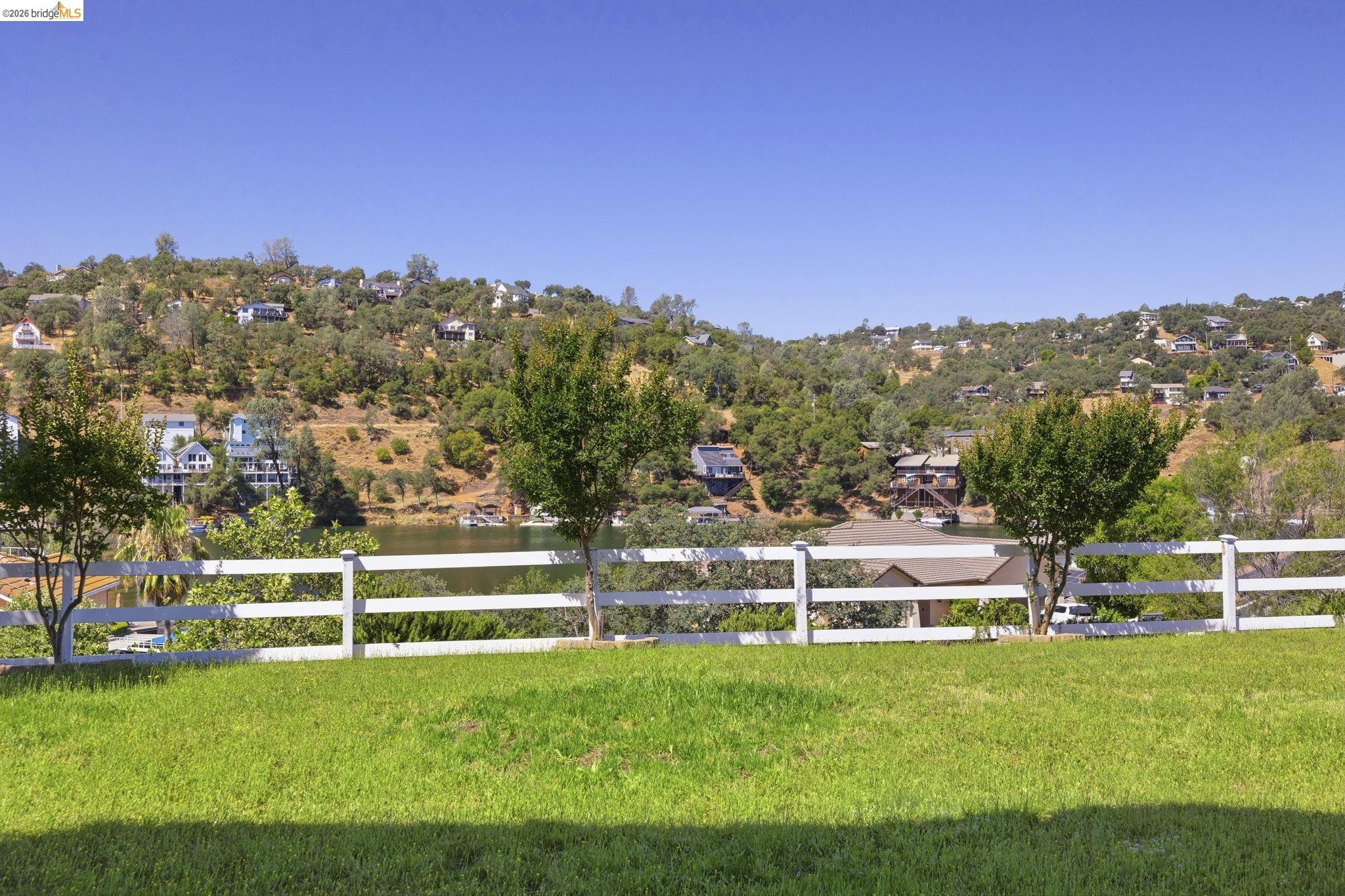 6242 Bluff View Road Copperopolis, CA 95228 - Photo 47 of 59 Expansive grassy lawn offering a scenic backdrop of the lake and tree-covered hillsides. Perfect for a new infinity pool, outdoor kitchen or patio for entertaining large crowds.