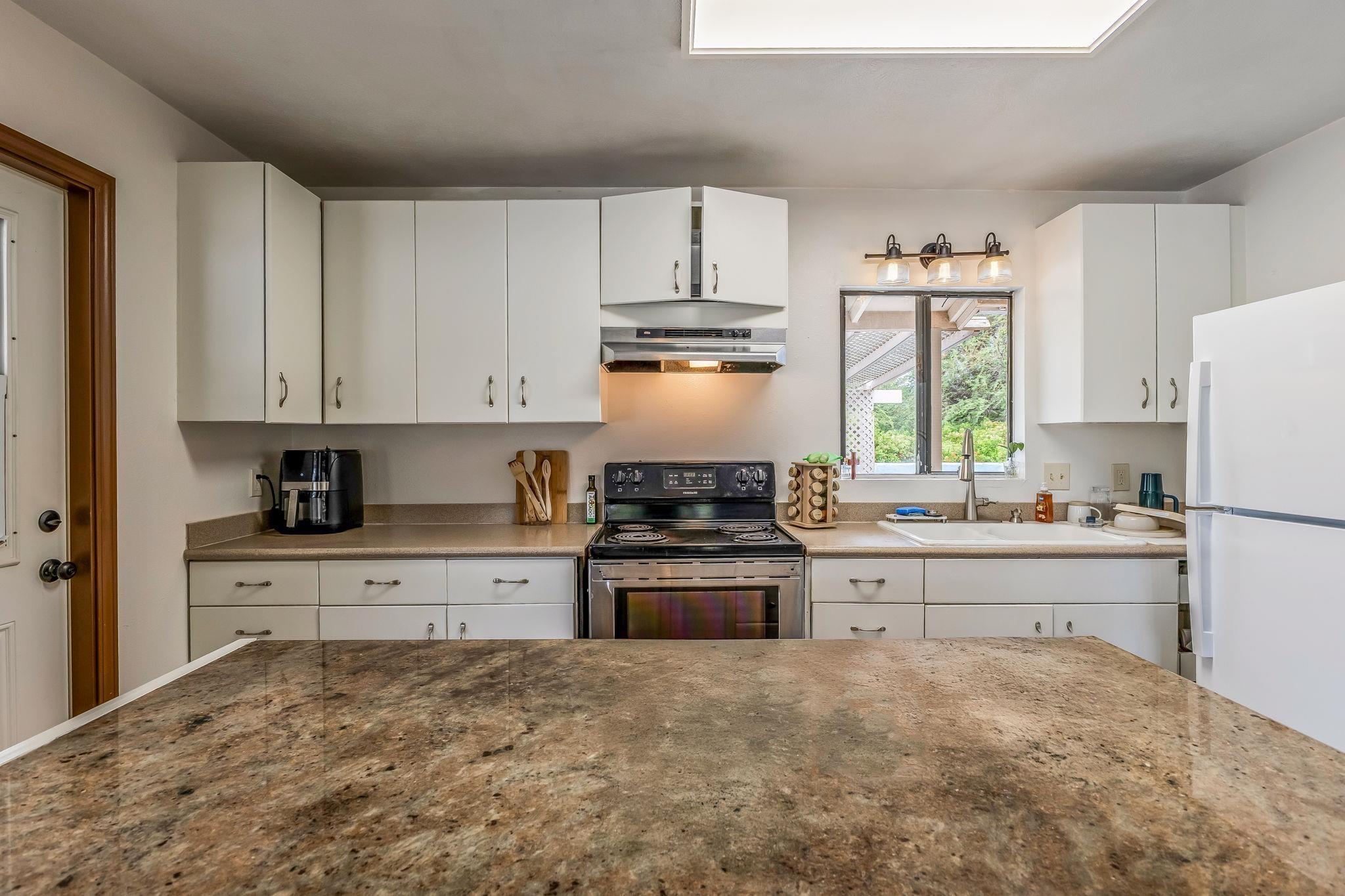 1156 South Kihei Road Kihei, HI 96753 - Photo 15 of 25 a kitchen with a stove a refrigerator and a sink