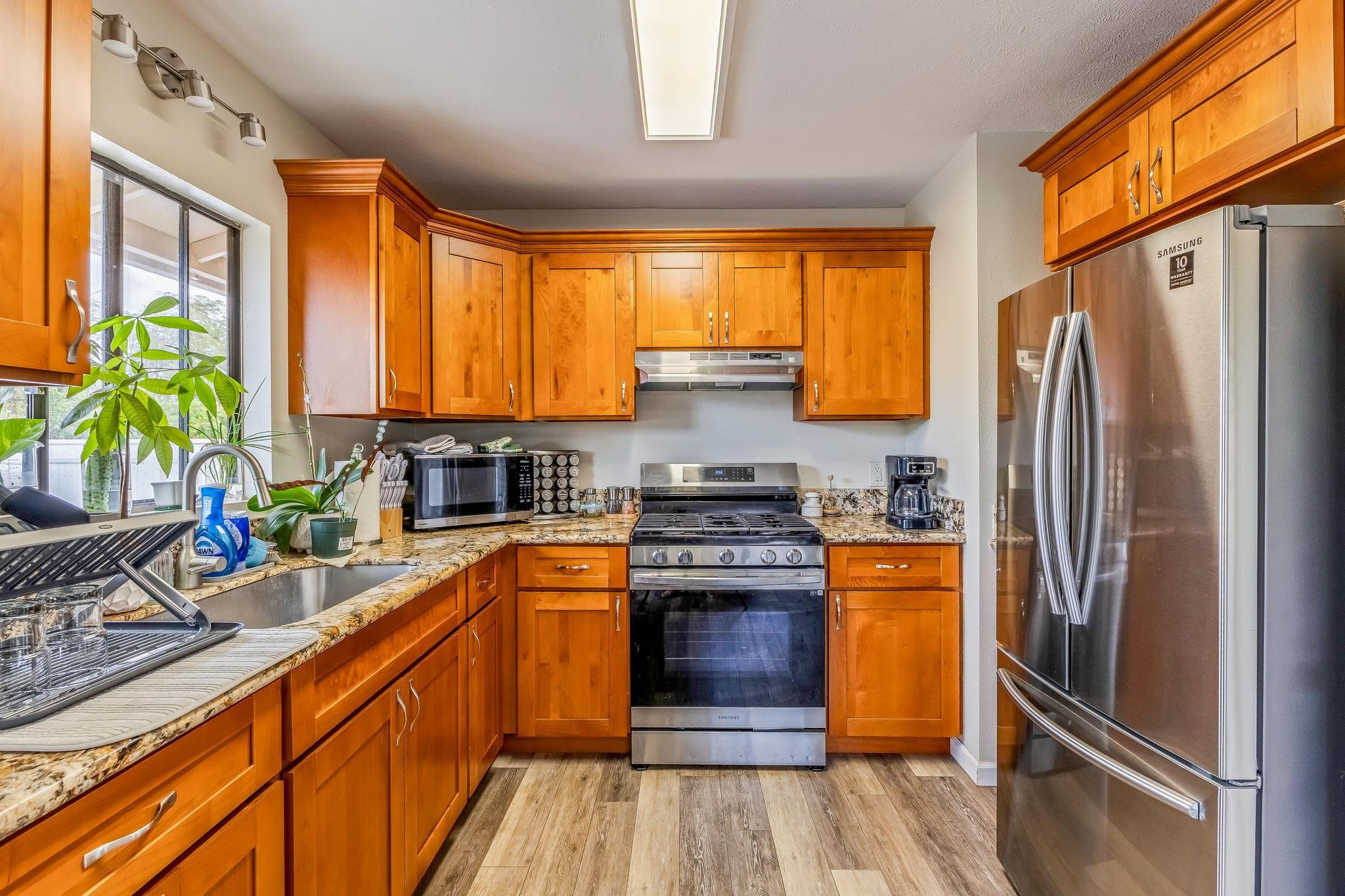1156 South Kihei Road Kihei, HI 96753 - Photo 2 of 25 a kitchen with stainless steel appliances a refrigerator sink and wooden cabinets