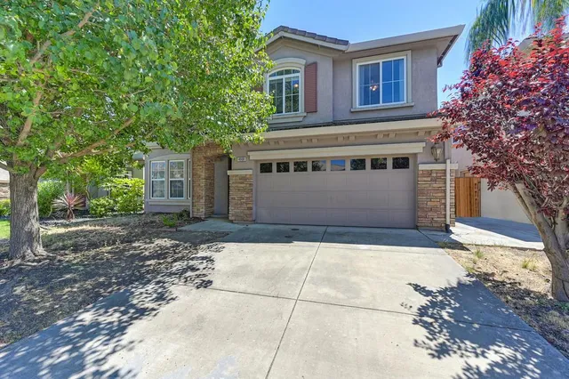 a front view of a house with a yard and garage