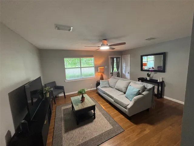 a living room with furniture a flat screen tv and a window