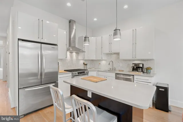 a kitchen with white cabinets and refrigerator