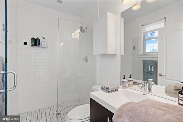 a bathroom with a sink toilet a mirror and shower