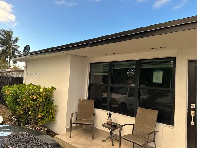 a backyard of a house with table and chairs