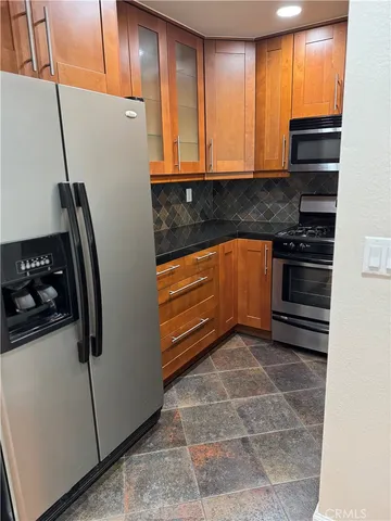 a kitchen with granite countertop cabinets stainless steel appliances and a window