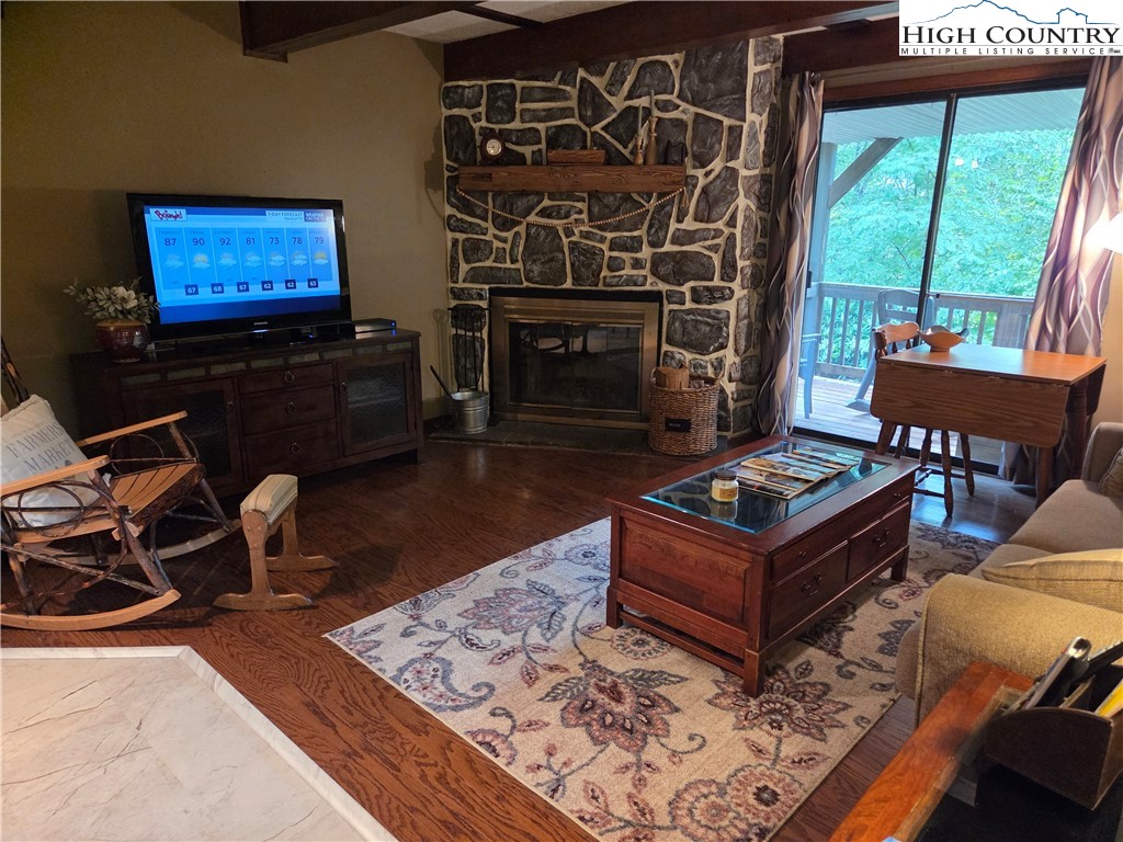 24 Laurel Ridge, Unit C Banner Elk, NC 28604 - Photo 2 of 14 a living room with furniture flat screen tv and a fireplace