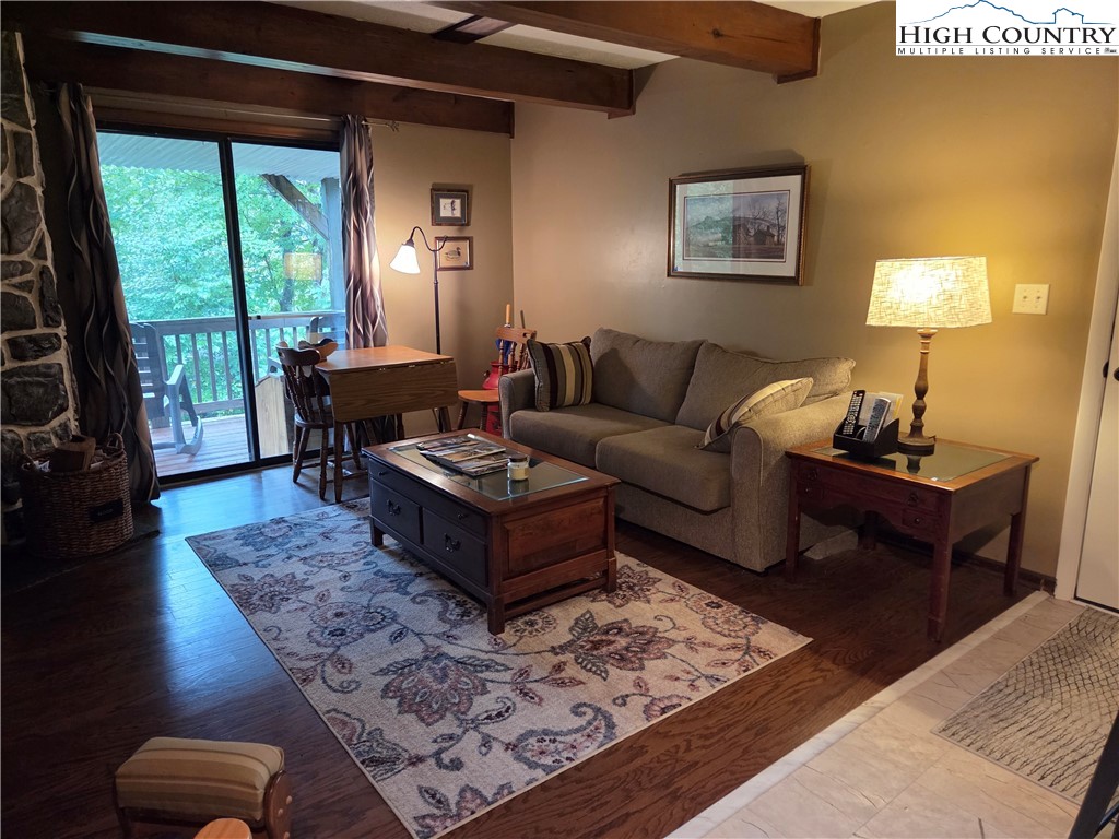 24 Laurel Ridge, Unit C Banner Elk, NC 28604 - Photo 3 of 14 a living room with furniture a lamp a rug and a large window