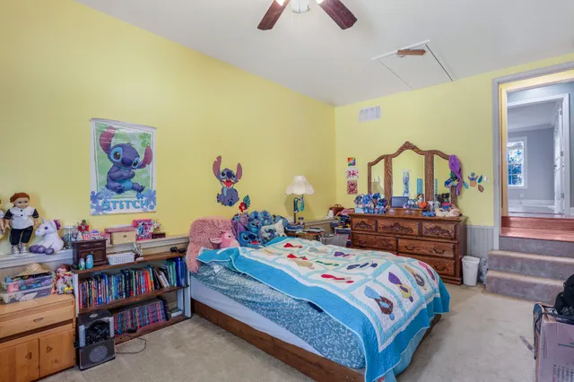a bedroom with bed and paintings on the wall