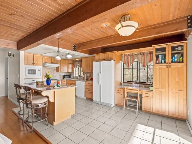 a living room with furniture and a dining table with kitchen view