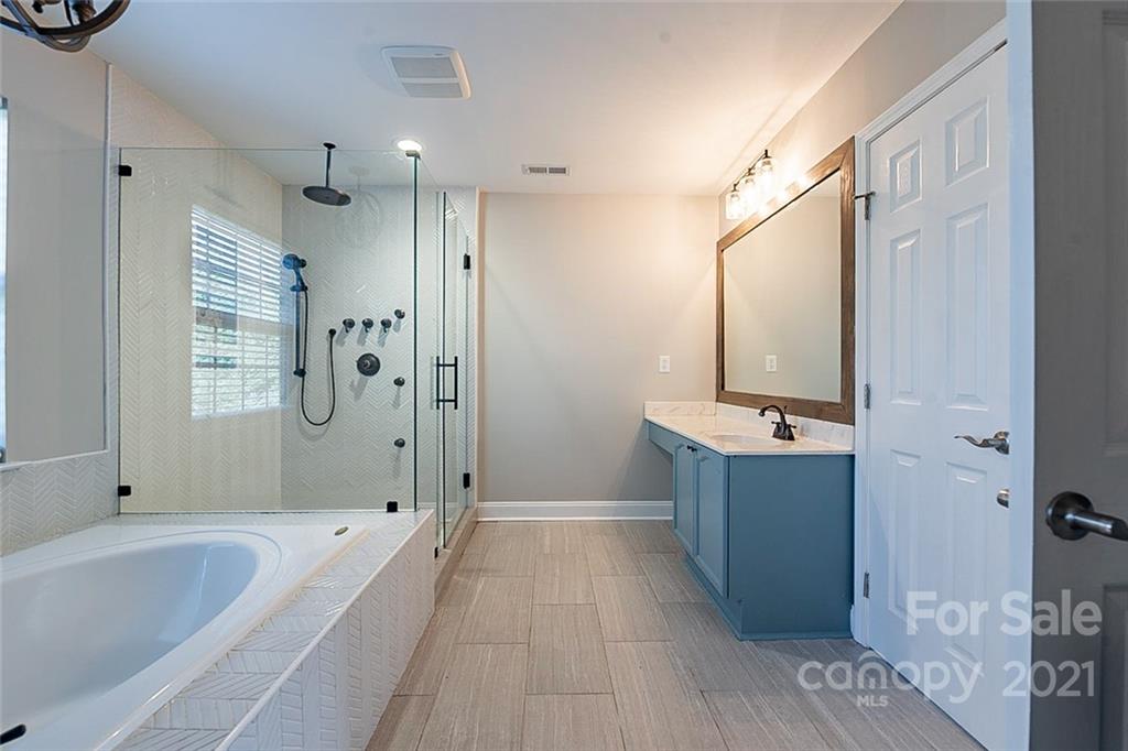 708 Knightswood Road Fort Mill, SC 29708 - Photo 22 of 28 a bathroom with a tub a sink and mirror