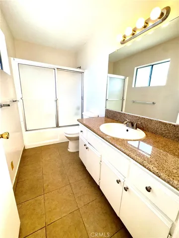 a spacious bathroom with a granite countertop sink and a mirror