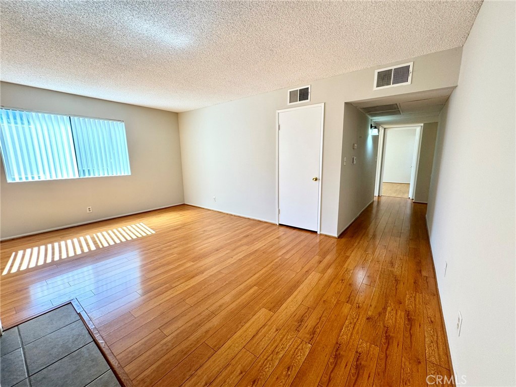 430 East San Jose Avenue, Unit F Burbank, CA 91501 - Photo 4 of 16 a view of an empty room with wooden floor and a window