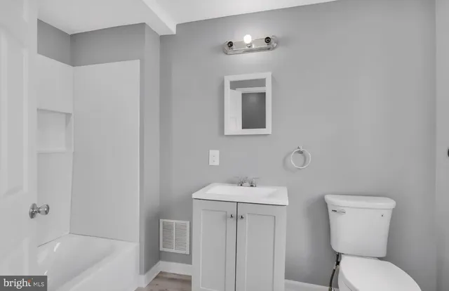 a bathroom with a toilet sink and mirror