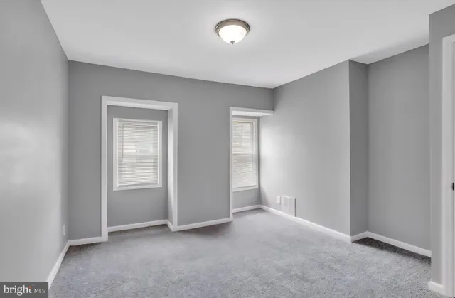 an empty room with windows and closet