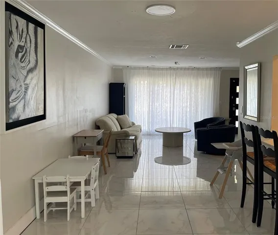 a living room with furniture a large window and a table