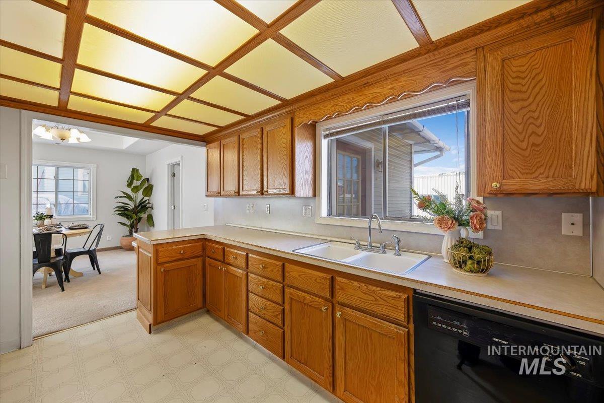 717 E Street Rupert, ID 83350 - Photo 13 of 24 Kitchen featuring light floors, brown cabinets, dishwasher, and light countertops