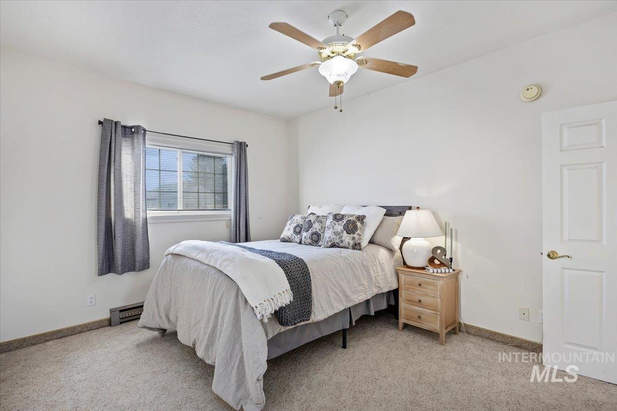 717 E Street Rupert, ID 83350 - Photo 17 of 24 Bedroom featuring light carpet, ceiling fan, and baseboard heating