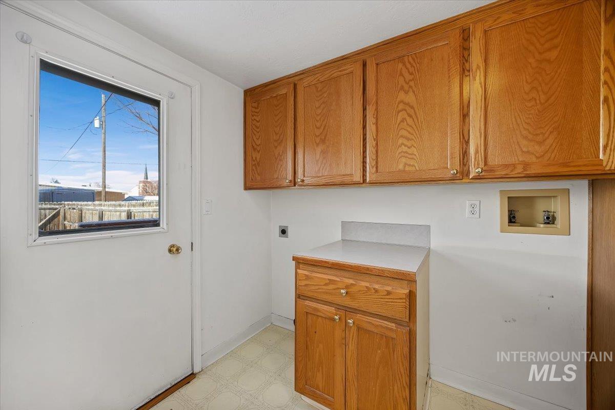 717 E Street Rupert, ID 83350 - Photo 21 of 24 Laundry room featuring light floors, electric dryer hookup, cabinet space, and washer hookup