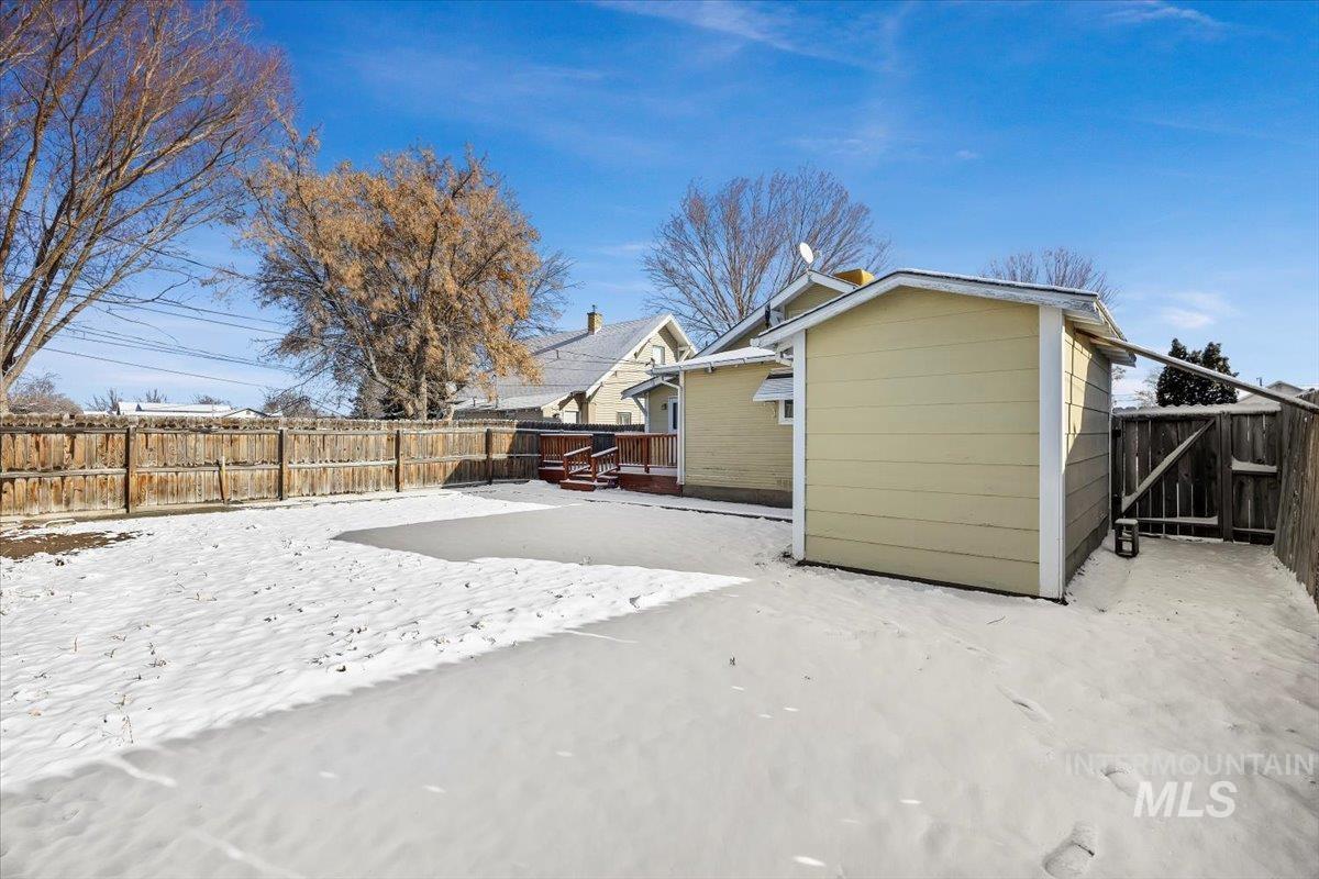 717 E Street Rupert, ID 83350 - Photo 23 of 24 Snow covered property with a fenced backyard and a deck