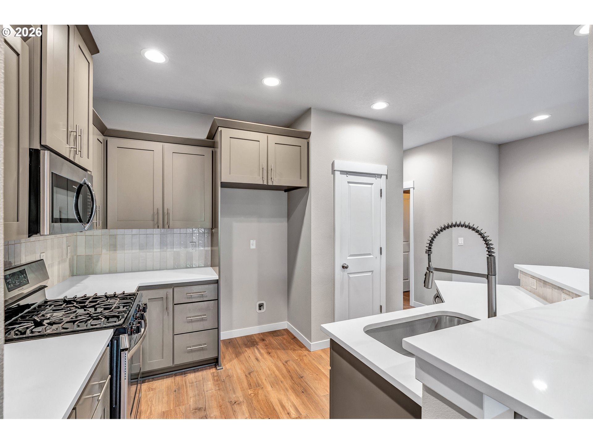 12706 Southeast Zion Street Boring, OR 97089 - Photo 11 of 34 a kitchen with stainless steel appliances kitchen island a refrigerator a sink a stove and white cabinets