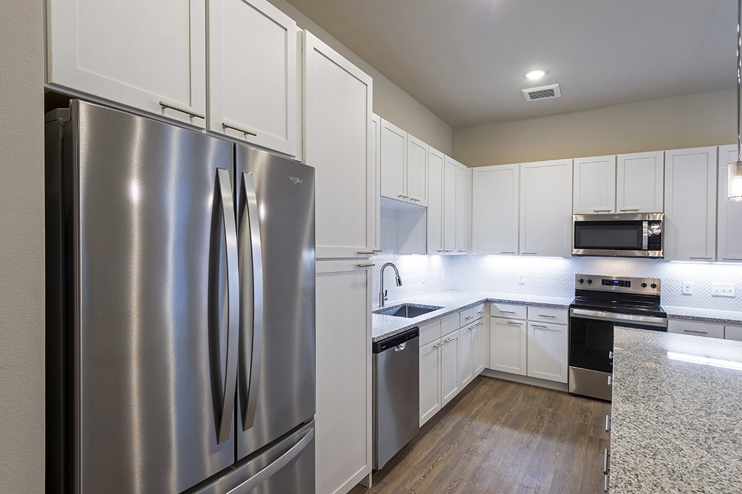 1724 Partnership Way, Unit 3103 Katy, TX 77449 - Photo 25 of 34 a kitchen with stainless steel appliances granite countertop a refrigerator stove top oven and sink