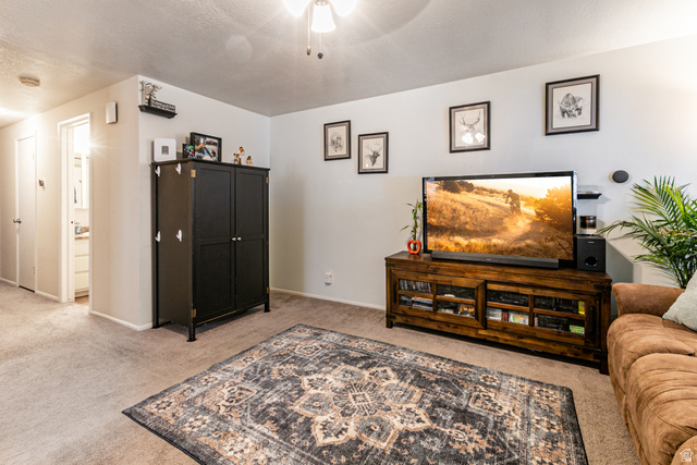 947 Canyon Road, Unit 33 Ogden, UT 84404 - Photo 9 of 19 Carpeted living area featuring light neutral wall tones and a ceiling fan with integrated lighting
