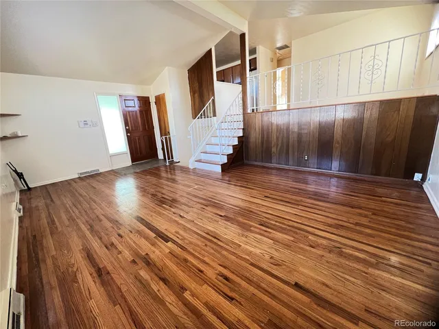 a view of an empty room with wooden floor
