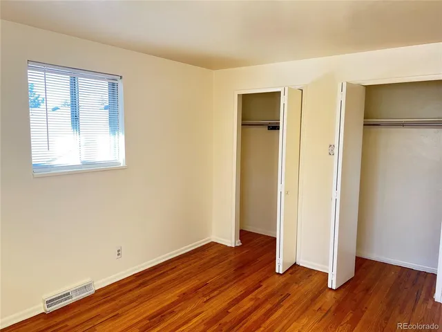 an empty room with wooden floor and a window