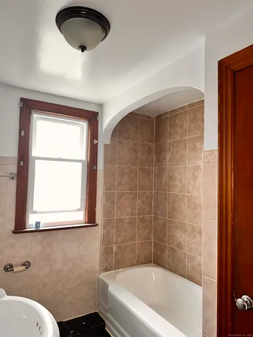 a bathroom with a bathtub and a window