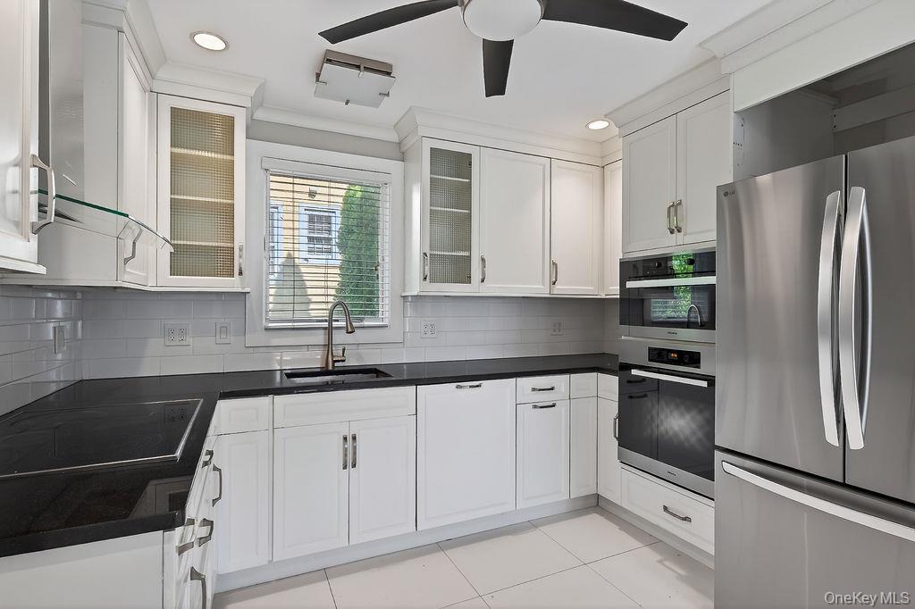 155 White Road Scarsdale, NY 10583 - Photo 5 of 30 a kitchen with white cabinets and stainless steel appliances