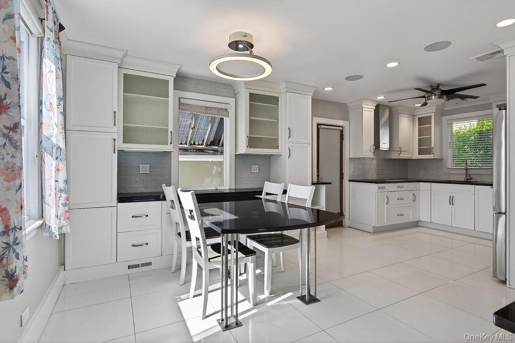 155 White Road Scarsdale, NY 10583 - Photo 6 of 30 a kitchen with stainless steel appliances kitchen island granite countertop a table and chairs in it