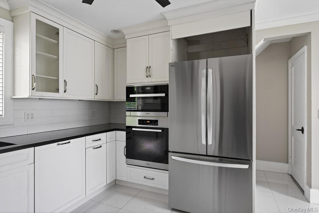 155 White Road Scarsdale, NY 10583 - Photo 8 of 30 a kitchen with stainless steel appliances white cabinets and a refrigerator