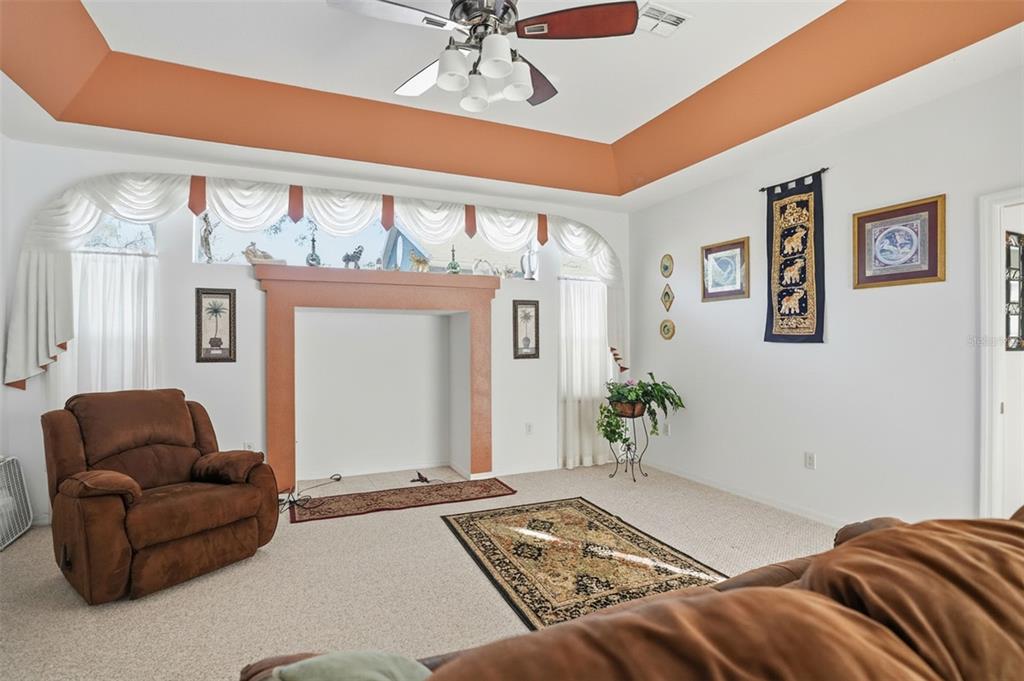 12054 Conway Street Spring Hill, FL 34609 - Photo 11 of 49 a bedroom with a bed couches and a chandelier