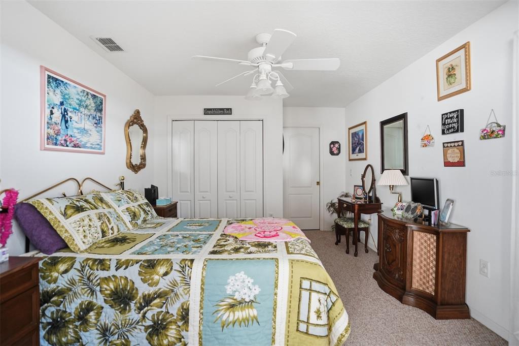 12054 Conway Street Spring Hill, FL 34609 - Photo 15 of 49 a bedroom with a bed and a chandelier