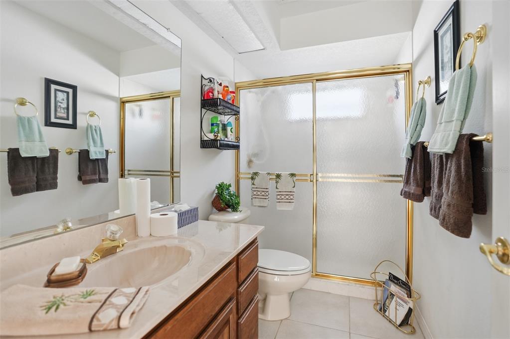 12054 Conway Street Spring Hill, FL 34609 - Photo 18 of 49 a bathroom with a granite countertop sink a toilet and shower
