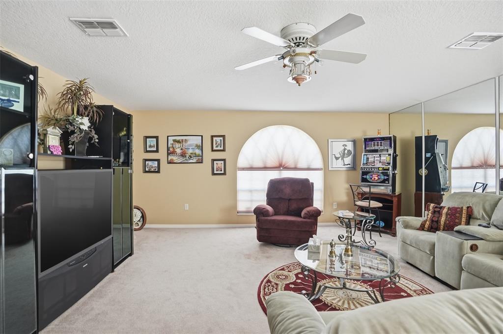 12054 Conway Street Spring Hill, FL 34609 - Photo 27 of 49 a living room with furniture a chandelier and a large window