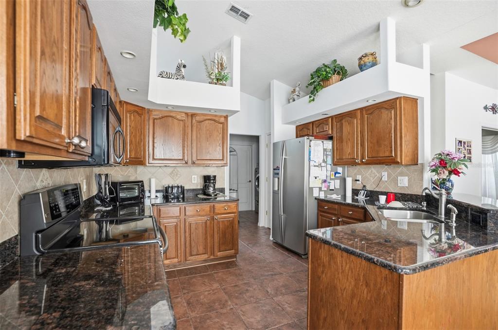 12054 Conway Street Spring Hill, FL 34609 - Photo 8 of 49 a kitchen with stainless steel appliances granite countertop a sink a stove and a wooden floors