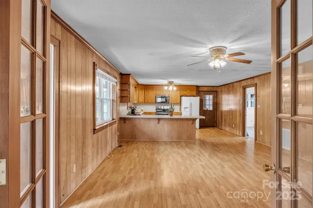 a view of kitchen with kitchen island wooden floor center island and stainless steel appliances