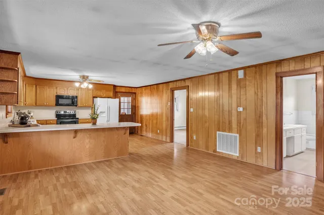 a large kitchen with cabinets and wooden floor