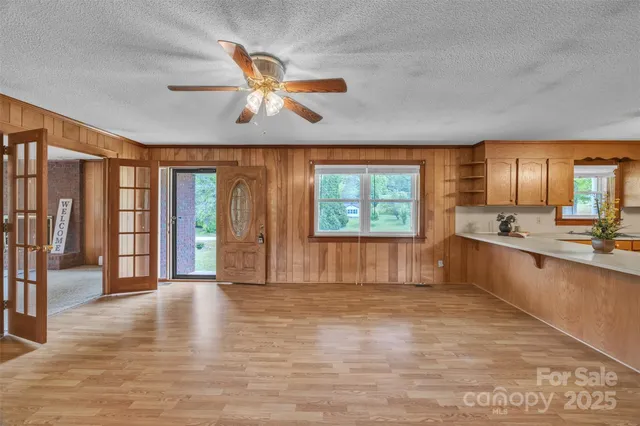 a view of an empty room with window and wooden floor