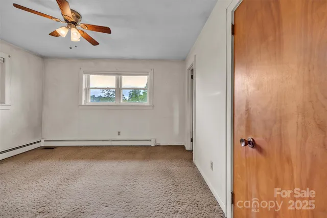 an empty room with windows and fan