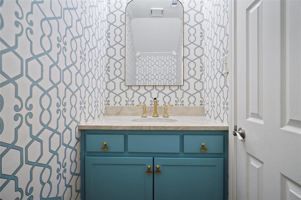 1229 Wooded Trail Hurst, TX 76053 - Photo 15 of 28 Downstairs half bath featuring beautiful wallpaper and vanity with brushed gold fixtures.
