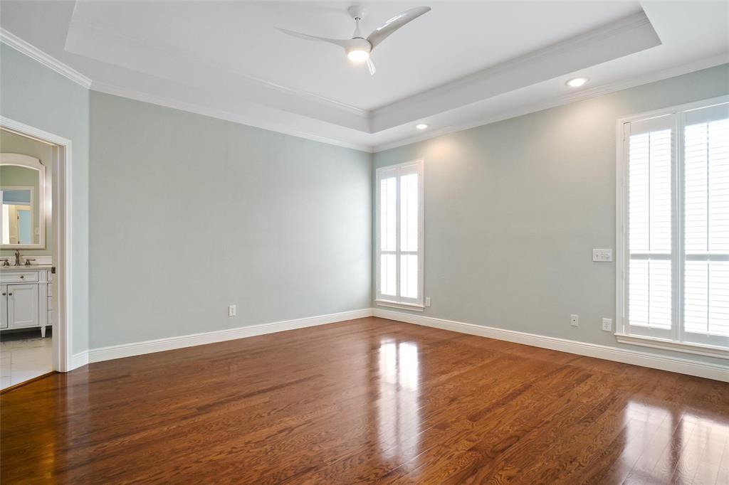 1229 Wooded Trail Hurst, TX 76053 - Photo 18 of 28 Primary bedroom room with dark wood-style flooring, ornamental molding, a tray ceiling, ceiling fan, and recessed lighting