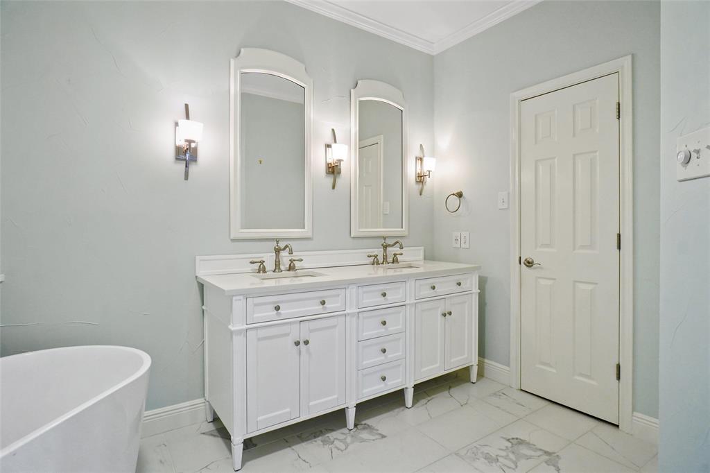 1229 Wooded Trail Hurst, TX 76053 - Photo 20 of 28 Primary bathroom with double vanity, light marble finish flooring, a freestanding bath, and crown molding