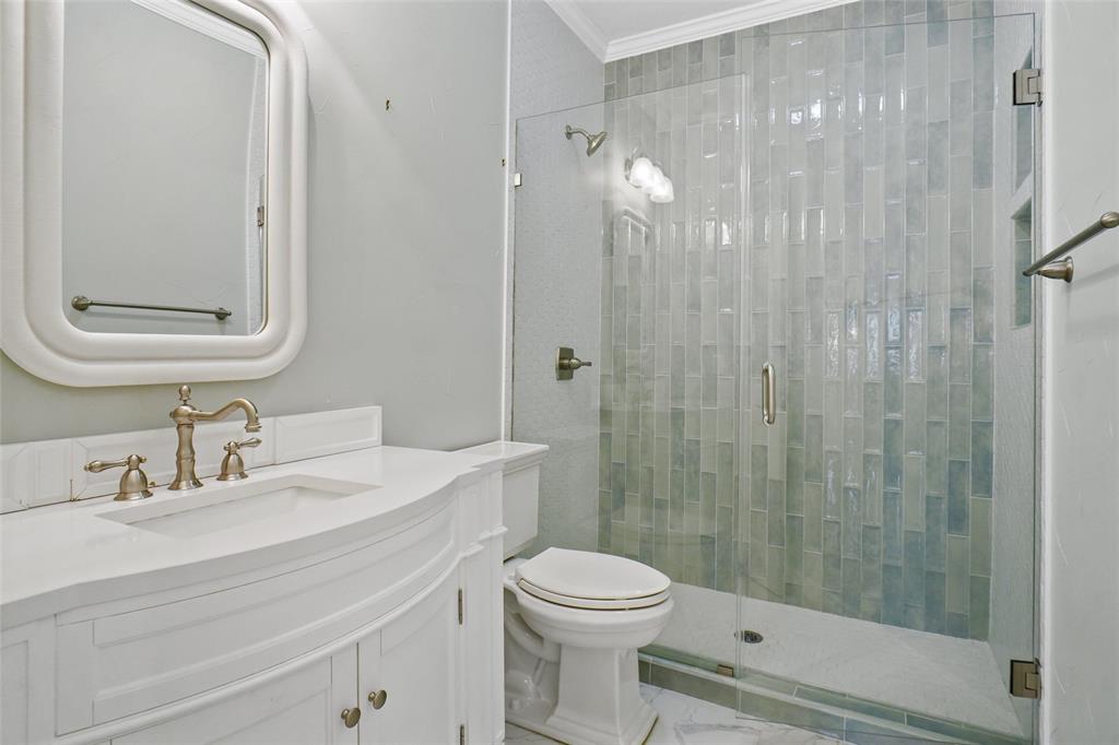 1229 Wooded Trail Hurst, TX 76053 - Photo 24 of 28 Full bathroom featuring vanity, a shower stall, ornamental molding, and marble look tiles